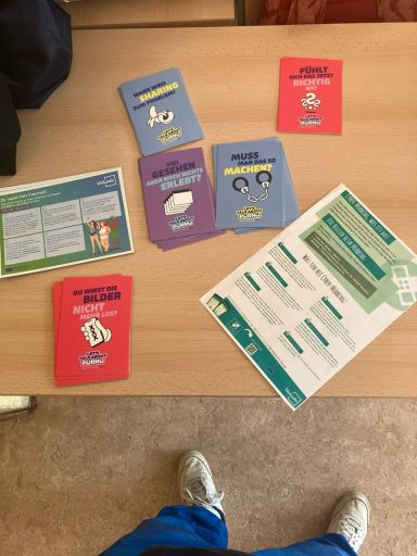 Schulprojekt Selbstbehauptung & Selbstverteidigung für Mädchen 14-18 Jahre Karten und Informationsblätter auf einem Tisch, themenbezogen und bunt gestaltet.